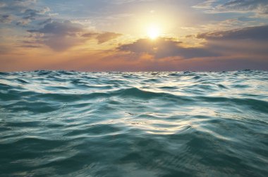 Renkli dramatik gökyüzü bulutlarının doğa arka planı ve gün batımında deniz dalgaları yansıması. Tasarım elementi. 