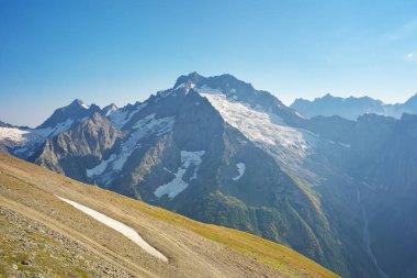 Dombay Ulgen Dağı buzulu ve gün içinde yeşil bir çayır. Doğa manzarası.