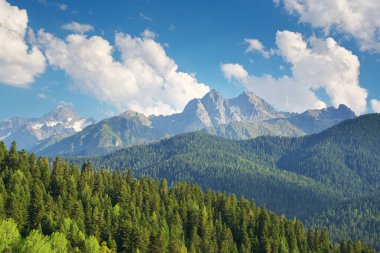 Dağlık alanda bir manzara ve gündüz bulutlu mavi bir gökyüzü. Doğa manzarası.