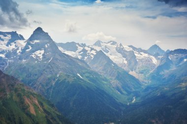 Bulutlu bir günde Dombay Ulgen Dağı buzulu ve miyav. Doğa manzarası.