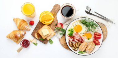 İngiliz kahvaltısı, kızarmış yumurta, sosis, pastırma ve beyaz arka planda tost. 