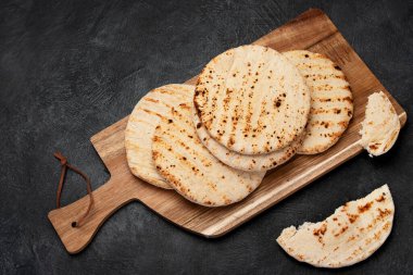 Koyu bir arka planda izole edilmiş Pita ekmeği. Geleneksel ve tipik Arap yemekleri. Üst görünüm.