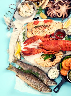 Çeşitli deniz ürünleri ve balık yemekleri. Mavi arka planda sağlıklı gıda konsepti, üst görünüm