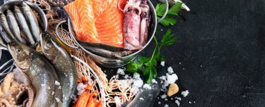 Taze balık ve deniz ürünleri çeşitleri kara arka planda, balık pazarında. Sağlıklı beslenme konsepti. Üst görünüm, boşluğu kopyala. Panorama, bayrak