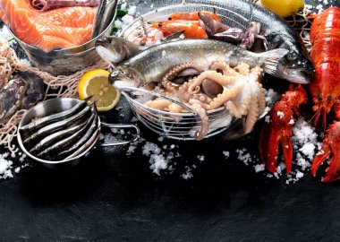 Taze balık ve deniz ürünleri çeşitleri kara arka planda, balık pazarında. Sağlıklı beslenme konsepti. Üst görünüm., Boşluğu kopyala.