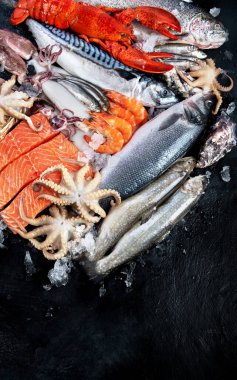 Taze balık ve deniz ürünleri çeşitleri kara arka planda, balık pazarında. Sağlıklı beslenme konsepti. Üst görünüm., Boşluğu kopyala.
