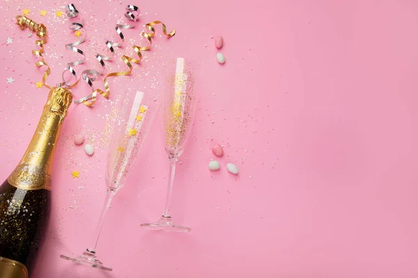 香槟酒瓶 带有粉红背景的意粉 节日装饰和金色节日派对的彩旗 创意概念 顶部视图 复制空间 — 图库照片