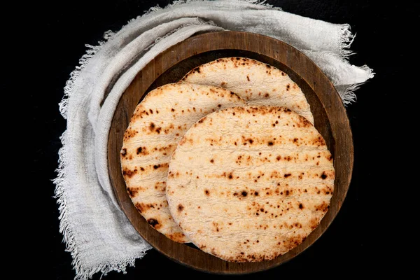 Pita bread isolated on a dark background. Traditional and typical food of Arabic cuisine. Top view.