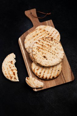 Koyu bir arka planda izole edilmiş Pita ekmeği. Geleneksel ve tipik Arap yemekleri. Üst görünüm.