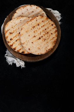 Koyu bir arka planda izole edilmiş Pita ekmeği. Geleneksel ve tipik Arap yemekleri. Üst görünüm.