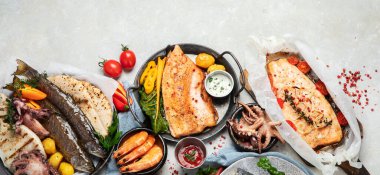 Deniz ürünleri tabağı. Gri arka planda sebzeli lezzetli deniz ürünleri. Üst Manzara. Kopyalama alanı olan Panorama.