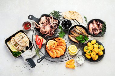 Deniz ürünleri tabağı. Gri arka planda sebzeli lezzetli deniz ürünleri. Üst görünüm.