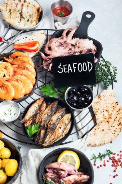 Deniz ürünleri tabağı. Gri arka planda sebzeli lezzetli deniz ürünleri. Üst görünüm.