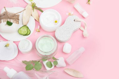 Pembe arka planda yüz ve vücut bakım ürünleri. Doğal kozmetikler. Üst görünüm, düz görünüm, kopyalama alanı