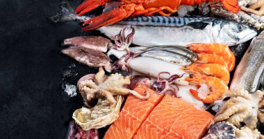 Taze balık ve deniz ürünleri çeşitleri kara arka planda, balık pazarında. Sağlıklı beslenme konsepti. Üst görünüm., Boşluğu kopyala.