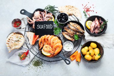 Deniz ürünleri tabağı. Gri arka planda sebzeli lezzetli deniz ürünleri. Üst görünüm.