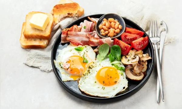 全英式早餐 有煎蛋 熏肉和灰色背景的吐司 — 图库照片