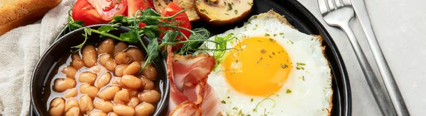 全英式早餐 配上煎蛋 熏肉和灰色背景的吐司 — 图库照片