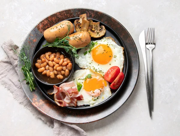 全英式早餐 配上煎蛋 熏肉和灰色背景的吐司 顶部视图 — 图库照片