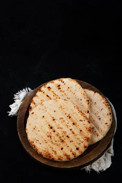Pita bread isolated on a dark background. Traditional and typical food of Arabic cuisine. Top view.