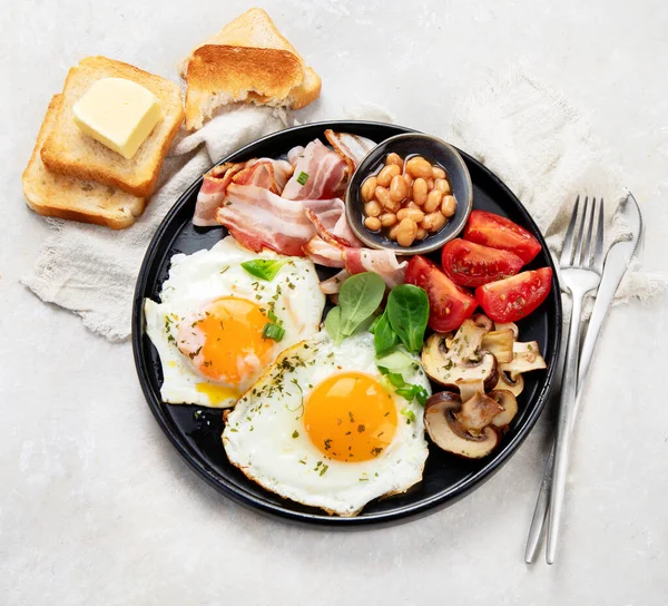 目玉焼き ソーセージ ベーコン トーストとグレーの背景でフル英語の朝食 トップビュー コピースペース — ストック写真