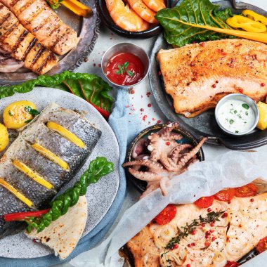 Deniz ürünleri tabağı. Gri arka planda sebzeli lezzetli deniz ürünleri. Üst görünüm.