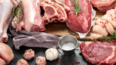 Farklı türde çiğ et - sığır eti, domuz eti, kuzu, arka planda tavuk.