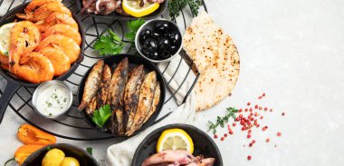 Deniz ürünleri tabağı. Gri arka planda sebzeli lezzetli deniz ürünleri. Üst Manzara. Kopyalama alanı olan Panorama.