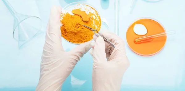 stock image Medicine research of curcuma properties with the help of laboratory equipment, woman in gloves testing turmeric powder. Top view