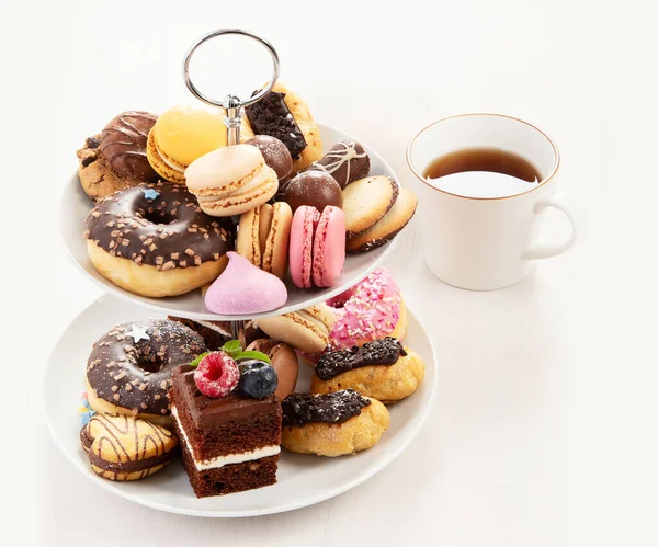 Cake stand with macaroons, mini cakes, cookies for tea.