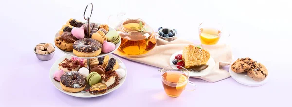 伝統的な英語のお茶 紫色の背景にお菓子の選択とアフタヌーンティー 休日のコンセプト パノラマ バナー — ストック写真