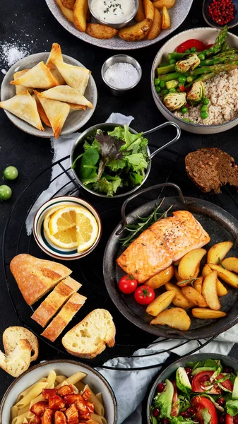 各式主菜 不同的健康主菜 肉类和鱼类菜肴 意大利面 面包和蔬菜在黑暗的背景下 顶部视图 — 图库照片