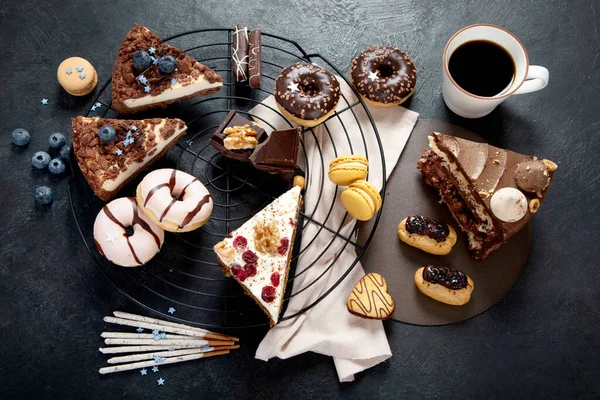 様々なクッキー ドーナツ ケーキ 暗い背景にチーズケーキとテーブル おいしいデザートテーブル トップビュー フラットレイアウト — ストック写真