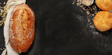 Bread assortment on dark background. Fresh homemade pastry. Top view, copy space