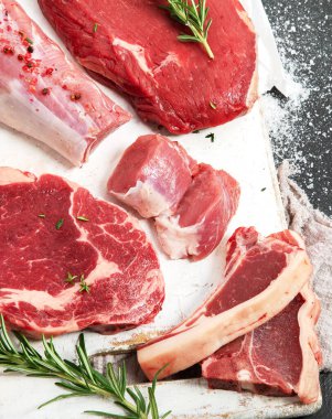 Farklı türde çiğ et. Sığır eti, domuz eti, kuzu eti, arka planda tavuk. Üst manzara, düz uzanma