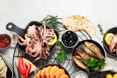 Deniz ürünleri tabağı. Gri arka planda sebzeli lezzetli deniz ürünleri. Üst görünüm.