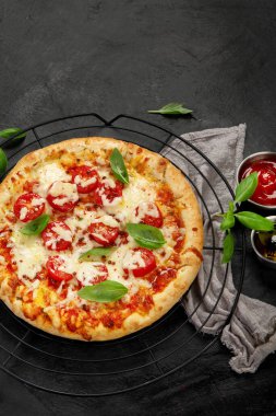 Freshly baked pizza on dark background. Tasty homemade food concept. Top view, copy space