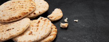 Koyu bir arka planda izole edilmiş Pita ekmeği. Geleneksel ve tipik Arap yemekleri. Üst Manzara. Kopyalama alanı olan Panorama.