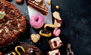 Şekerleme çeşitleri, karanlık masadaki farklı tatlılar. Üst görünüm, alanı kopyala