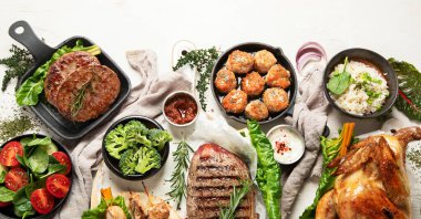 Çeşitli türde sağlıklı pişirilmiş et - sığır eti, domuz eti, pirinçli, sebzeli ve salatalı hafif arka planda tavuk. Üst görünüm.