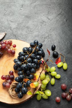 Tahta bir tabakta yeşil ve siyah üzümler. Üst görünüm.