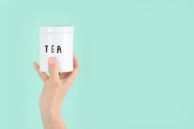 Yeşil arka planda çay fincanı tutan kollar havada. Kavramsal fotoğraf. Ön görünüm