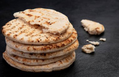 Koyu bir arka planda izole edilmiş Pita ekmeği. Geleneksel ve tipik Arap yemekleri. Üst görünüm.