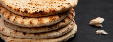 Koyu bir arka planda izole edilmiş Pita ekmeği. Geleneksel ve tipik Arap yemekleri. Üst Manzara. Panorama.