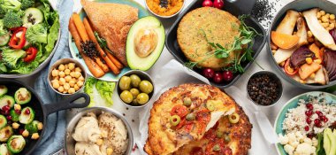 Gri masada vejetaryen ve çeşitli vejetaryen yemekleri. Vitaminli, lifli ve antioksidanlı sağlıklı gıda konsepti. Üst Manzara. Panorama.