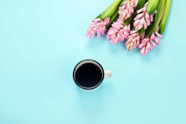 Morning cup of coffee and pink spring flowers on blue background. Breakfast for Birthday, Holiday, Women day, Mother day, Valentine's Day concept