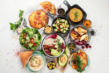 Gri masada vejetaryen ve çeşitli vejetaryen yemekleri. Vitaminli, lifli ve antioksidanlı sağlıklı gıda konsepti. Üst görünüm.