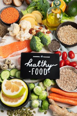 Beyaz arka planda sağlıklı yiyecek seçimi. Detoks ve temiz diyet konsepti. Yüksek miktarda vitamin, mineral ve antioksidan içeren yiyecekler. Yaş karşıtı yiyecekler. Üst görünüm.