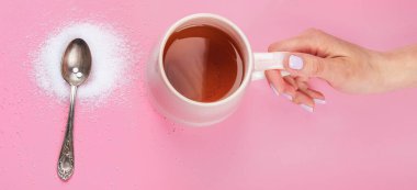 Cup of tea with sugar substitute on pink background. Healthy hot beverage. Top view, flat lay, copy space