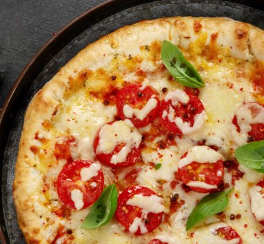 Freshly baked pizza on dark background. Tasty homemade food concept. Top view, copy space